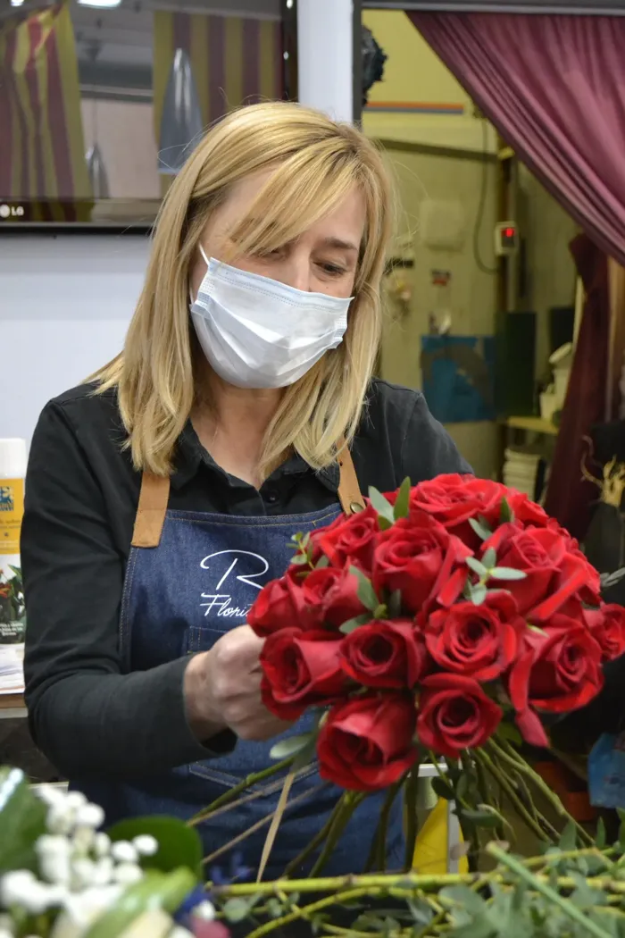 Florista preparando un ramo de rosas rojas